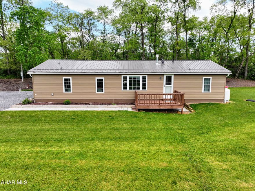 Who doesn't like a room with a view! This newly updated ranch sits on 3 beautiful, serene acres in Bedford County. This retired doublewide is secure on concrete blocks. In 2020 a new (40 year) roof, siding, windows, and doors were completed. A front deck, paver sidewalks and large concrete patio are ready for company! The back embankment is ready for you to add whatever annuals or shrubs you want to plant and make it yours. Inside, this home boasts of 3 bedrooms and 2 full baths. A laundry area and a breakfast nook let in plenty of sunshine. A perfect area for all of your plants! The galley kitchen has newer cabinets and countertops and has plenty of storage. Full open concept living with the dining and living areas. There is access to walk out onto the back patio from the dining room. From the living area you can cozy up and enjoy the warmth of the brand new (2024) stone and propane fireplace! Or take your gaze right out of the large family window and take in the views of the Allegheny Mountains! Beautiful farm land and neighbors spotted around. Even with 220 South nearby, the traffic noise is not a problem. The master bedroom has plush carpet and is large enough for a king bed and furniture. A large closet and an immaculate master bath make this bedroom perfect. Open the french doors to the bonus room and make it your own space -an office, art or craft room, or even a 4th bedroom. It's even complete with a closet. At the other end of the home is another full bath for guests, and two bedrooms with closets and plush carpet. If you're handy or need a work shop, you won't be disappointed. A brand new electric garage door and new epoxy floor are waiting for you inside this 29'x15'3'' garage with work space counters and storage space. Park your car, motorcycles, truck or large RV in here if you desire. A 28'x12' Shawnee Structure has been added for even MORE storage. And it doesn't stop there! There have been custom blinds made for inside the home, keyless entry, a Vivint Security system ready to go; and then outside you'll find an underground pet fence that gives a large range for your furry friends to roam! And never get on the roof to clean a gutter again... this home comes with Leaf Filter on the gutters, with a lifetime warranty. An outdoor fire pit and lots of extra wood are included along with a freeze free spigot to hook up your garden hose to for all those summer water games or to water your garden. Any which way you look at it, this home is a must see. Close to Bedford and Cumberland, or a short drive to Rt 30 or the turnpike, this home is sure to please!