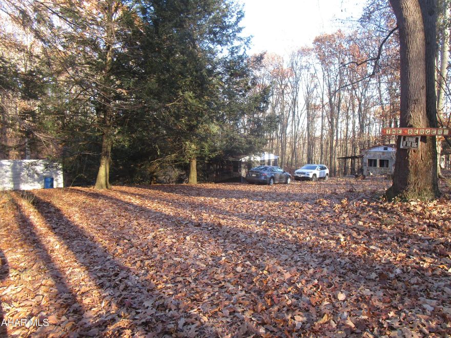 CASH ONLY - AS-IS, WHERE-IS.  AN IDEAL CABIN (TLC needed).  PRIVATE, WOODED SETTING. NO JUNK YARDS RESTRICTION. Buyers to confirm site area, boundary lines, taxes, sq, ft. gross liv. area; status of a septic.  Needs a well;  has a ''rain water collection system''; drink. water bottled/purchased. A  '72+-,Boise trailer - NO title.  Stone ext, walls around trailer need sealed off (squirrels, etc. get inside).  Penelec ; Martin Oil.   Was Dish TV & Hughes Net.  Private rd. maintenance. In Dev. of Mowry Acres - unknown if there are restrictions. Serene, wooded setting 3 mi. from Shawnee St. Park & Lake.