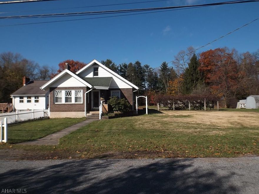 Convenient location in Eldorado on approx. one acre of level ground.  Huge three season room with gas heater, cherry kitchen, large living room with brick fireplace, sunroom, newer windows.  Spacious attic is heated and could be used for additional living space or bedroom.  Open patio with grape arbor and another private patio in the wooded area of the back yard has an outdoor fireplace or cooking area.  The framing is there for a greenhouse so you can get a head start on Spring planting. This home is in move in condition and convenient to shopping and I-99.