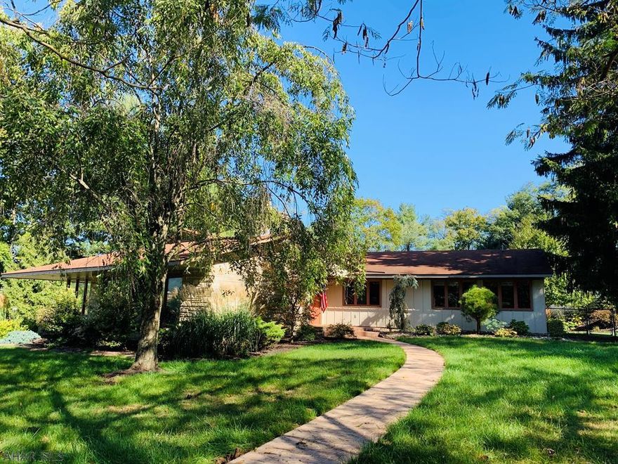 Imagine living in town but having a sense that you are surrounded by privacy and nature.  Large walls of glass allow exterior and interior spaces to blend seamlessly throughout.  A creative cook will delight in the spacious chef inspired kitchen with walls of windows, walk in pantries, granite wall which includes built in oven and fireplace.  Relax in the living and dining spaces that are filled with natural light while enjoying peace and solitude of a family room which opens onto a private terrace.  No expense was spared in the creation of two stunning bathroom renovations.  Natural gas energy efficiency radiant floor 4 zone heating, central air, main floor laundry, 2 fireplaces, double car garage plus 400 sq.ft. building add to the value.  A must see home that will not last long!