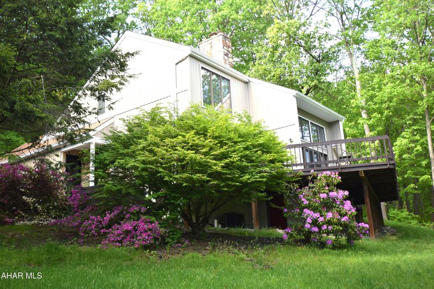 Beautifully remodeled contemporary style home with over 4000 square feet of finished living area and lots of upgrades!  The main floor features an open floor plan with spacious living room with wood burning fireplace,  eat-in kitchen with granite counter tops,  formal dining room, office, laundry and half bath.   Doors in the living room open to a large front facing deck with an incredible view.  Upper level features a primary bedroom suite with walk-in closet and newly remodeled bathroom.   There are two additional bedrooms on this level, another full bath, and a fourth room with skylights and closet that could definitely be used as a fourth bedroom.  The basement is full and nicely finished.  In addition to the family entertainment space, there is a (5th) bedroom and a full bath found here.   End your long day in the hot tub surrounded by the beautiful azaleas.  Upgrades include new vinyl siding, new furnace, and new water filtration system.  This great home is in the middle of a beautiful development,  but nature surrounds it making it feel like your own private corner of the world.