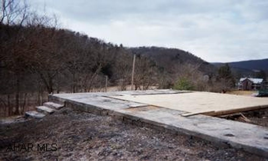 Vacant lot, foundation in place. Build your own home, mobile or modular. House foundation covered with sheeting.