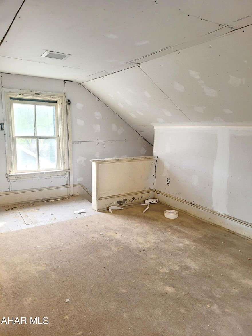 Attention investors! This project already has been started and is looking for your vision! This house features 2 bedrooms on the 2nd floor, and the potential for a bonus space on the 3rd floor. The full bath on the 2nd floor already has some beautiful tile work done. The first floor features a good size living room, a dining room with a bay window, a decent sized kitchen, and a small mud room that could be perfect for 1st floor laundry. Out back is a garage with two levels! The yard is almost completely fenced in. The front porch has plenty of space for relaxing. This one has a ton of potential - schedule your showing today to imagine how you could make it a show stopper!