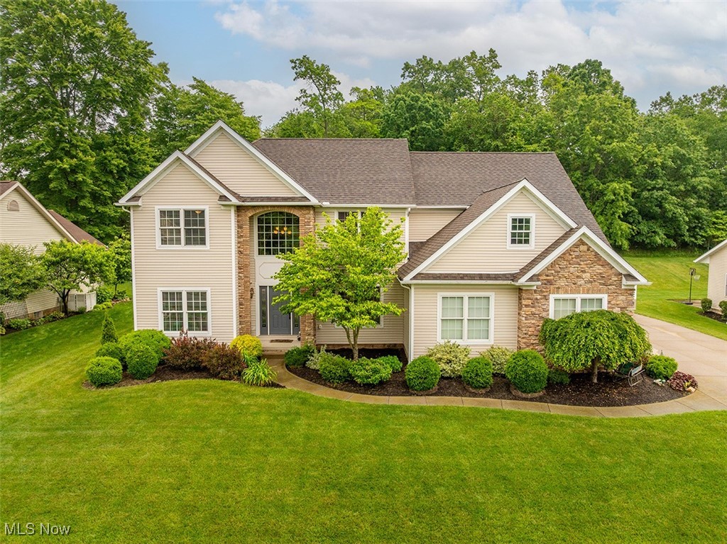 Come see this custom colonial built by Heritage Homes in the desirable Kings Ridge Neighborhood of Green. This gorgeous home has many amazing features and updates. The large two-story foyer makes a statement as you enter. A custom kitchen boasts beautiful solid maple cabinetry with new quartz counters and stainless appliances, a generous walk-in pantry, and an eat-in area well-lit by the large windows overlooking the quiet back yard. Off the kitchen is a small butler's pantry with extra storage, which can be used as a wine or coffee bar. The kitchen opens to the soaring family room with a grand two-story fireplace. In addition to the impressive living space, you will appreciate the first-floor office that can double as a 4th bedroom or guest room. The upstairs spacious bedrooms include a huge owner's suite with a seating area and two walk-in closets. Luxuriate in the master bath with his and hers vanities, large soaking tub, and huge spa shower with dual shower heads. Laundry is a breeze in the 2nd-floor laundry room. Outside, you will find a three-car attached garage with access to the basement with a full bath rough-in. The recently finished basement includes a soundproof office or a possible 5th bedroom, a built-in media center, half bath that is plumbed and ready for a shower to be installed. The tree-lined, private backyard is waiting for you to entertain or relax on the patio off the kitchen. The hot tub is currently on the patio and can be purchased with the home if desired. Don't miss touring this lovely home in its desirable location!