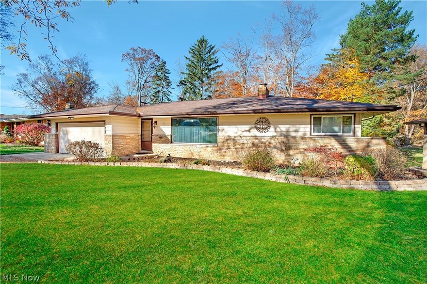 Beautifully updated and expanded stone ranch on private wooded lot. Large showcase kitchen addition with luxury finishes including granite counters and tiered eat-in island, countertop range, dual wall ovens, LOTS of cabinets and counter space, vaulted sitting room, slider to deck, ceiling fan, skylights with remote and sensor open/close system, glass pocket door, handscraped hardwood floors, and lots of natural light. Clean original hardwood floors throughout the rest of the 1st level. Large living room with stone wall wood-burning fireplace with gas starter (or gas logs.) Dining room has picture window overlooking scenic back yard. Newer windows, wood floors, clean baths. Remodeled 1/2 bath with pedestal sink & beadboard walls. Wood stairs to the finished walk-out lower level with all recessed lighting, double doors to lower patio, large windows, classic triple sink wet bar, 2nd stone wood-burning fireplace with heating insert, second kitchen, full bath, and huge storage room.....all