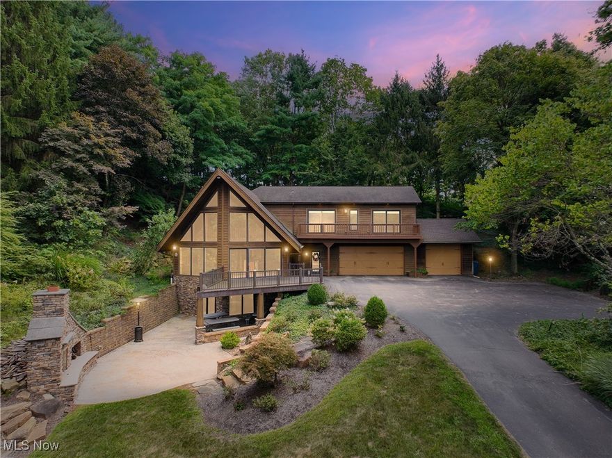 Welcome home to this A-frame, contemporary retreat with breathtaking views and timeless rustic charm! Once the beloved Akron Ski Club, this remarkable property has been thoughtfully remodeled to blend modern amenities with its original character. Step inside the dramatic great room, where oak-planked vaulted ceilings soar overhead and a stunning floor-to-ceiling stone fireplace creating a lodge-like atmosphere. The gourmet eat-in kitchen is a chef’s dream, featuring high-end appliances - including a commercial-grade 6-burner gas stove w/ pot filler, two dishwashers, and sleek granite countertops. Throughout the home, you’ll find Pella windows w/ privacy shades, five fireplaces, hardwood floors, and solid wood interior doors that showcase craftsmanship in every detail. The expansive primary suite — an impressive oasis, offers a private sanctuary to unwind, while 2 additional bedrooms and 4 full baths provide plenty of space for family and guests. The inviting den has finished log walls and sliding doors leading to the balcony is an ideal spot for focus and inspiration.
The lower level is a true highlight, designed with arched stone masonry and a convenient kitchenette — perfect for a home bar or second living suite! There is a full bath and new carpeting installed in the 4th bedroom. The oversized three-car garage offers access to the basement and the 3rd bay features a raised roof to accommodate your boat, motorhome, or large van. There’s no shortage of room to relax, entertain, and make memories. Step outside to enjoy the outdoor living space, complete with a striking stone fireplace, tranquil water feature, and panoramic views overlooking of Camp Y-Noah. Also, a landscaping rock wall ($40k) was added for outdoor appeal. Major updates include a 30-year shingle roof (2005), 1 of 2 furnaces (2021), and a refreshed driveway (2017). Don’t miss this rare opportunity to own a piece of local history with all the modern comforts — ready for you to call home and NO HOA!