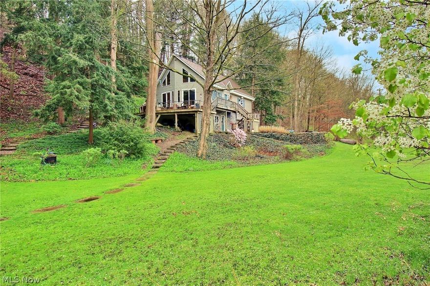 Open House Friday 4/26 4-6pm & Saturday 4/27 10am-12pm. 
Imagine living in your own nature preserve, overlooking the stunning Chagrin River.  This estate boasts trails leading to a breathtaking on-site waterfall—a priceless piece of nature that dreams are made of. The home features a spacious deck with picturesque views, a two-story living room with a European woodburning fireplace, and a well-equipped kitchen. Additional highlights include a versatile den/office/bedroom, convenient laundry room, a spacious bedroom, and a full bathroom on the main level. Upstairs, you'll find a cozy loft, a luxurious master suite with vaulted ceilings, and a bonus room or walk-in closet. The lower level offers a large workshop, another full bathroom, and a 2-car attached garage. With reinforced foundation and excellent drainage, this hillside home also includes radiant floor heating, plug-in generator, and central vacuum system for added convenience. Truly a gem, offering the most amazing property and scenic views along the riverfront— you're sure to fall in love with it!