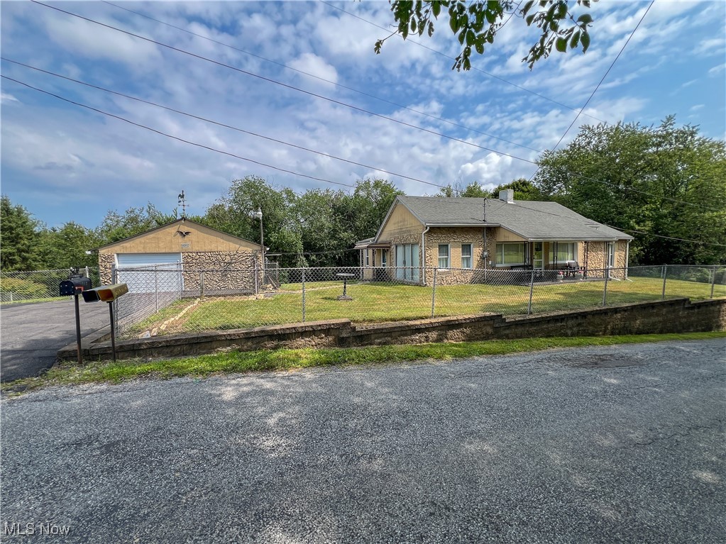 Ranch home with a fenced-in yard and a detached garage. The first floor has three-bedrooms, one full bathroom, laundry is located in the bathroom, a large living room, kitchen, and a family room. Outside the home has a detached garage with a workshop, a deck with a fireplace, a shed, a covered front porch, and a fenced in yard. Beaver local school district, dead end road, 1-mile from Calcutta shopping, and 2.5 mile from the Pennsylvania state line.