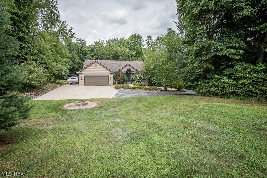 IF YOU'RE LOOKING FOR A PRIVATE RETREAT, THIS IS IT! Nestled in the woods at the end of a private drive you'll find this stunning raised ranch on 5 acres. The front of the home features an attached 2 car garage, parking pad and welcoming entrance. Step through the front door into the vaulted main level with an open layout. The formal dining room has gorgeous hardwood flooring & architectural beams. The living room has a ceiling fan, gas fireplace and is open to the eat-in kitchen with pantry, cherry cabinetry & stainless steel appliances. Patio doors lead to the large deck and private wooded view! The split bedroom design has the master suite on one side of the home & 3 more bedrooms on the opposite side with access to the main bath. A large laundry room with an abundance of cabinets & guest bath complete the main level. The lower level is finished with an Owens Corning system adding a spacious rec room with walk-out access to the covered patio. The basement has also been plumb