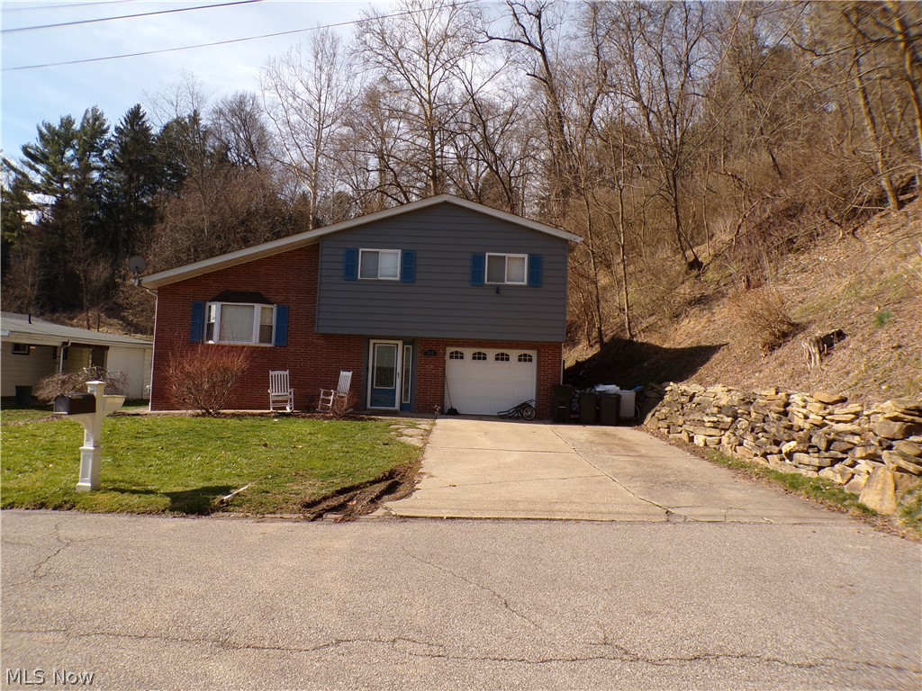 WELCOME TO 125 GREENTREE LANE!!! If you have been looking for a charming tri-level home, then here it is. Tucked back in, on a dead end street, this 3 bedroom, one and a half bathroom, MOVE IN READY home is located just minutes from everything Weirton has to offer, as it sits right outside of city limits. As you walk in the foyer, you are greeted by a beautiful, rustic, open space closet, perfect for backpacks, shoes and jackets to help keep the house clean and tidy. The freshly painted foyer is also where the laundry room and half bath combo are located, with the capability to be a full bath. The garage access is also off the foyer with plenty of space for your vehicle and more. As you walk up a few steps, you will enter into the bright and spacious living room, where you will find that there is more than enough room for the whole family to gather. The open concept, that flows into the eat in kitchen, pulls the main floor living space all together, where you will enjoy cooking and entertaining in your updated kitchen with stainless steel appliances, farmhouse sink, and brand new dishwasher makes it convenient for entertaining. When it's time for bed, head up a few more steps into the private area of the house, where you will lay down for the night in your, recently painted, master bedroom. There are 2 more spacious bedrooms for the kids or company, along with a full bathroom. Do you like to grill out? No problem! The backyard is perfect for relaxing after a long days work or a cup of coffee in the morning. This is a prime location for anyone who likes to fish as well. A 2 minute walk will put you right where you will want to be from February to May, when they stock trout in the creek during those months. If you are wanting to take a tour of this fabulous house contact me or your agent today to set up a showing!