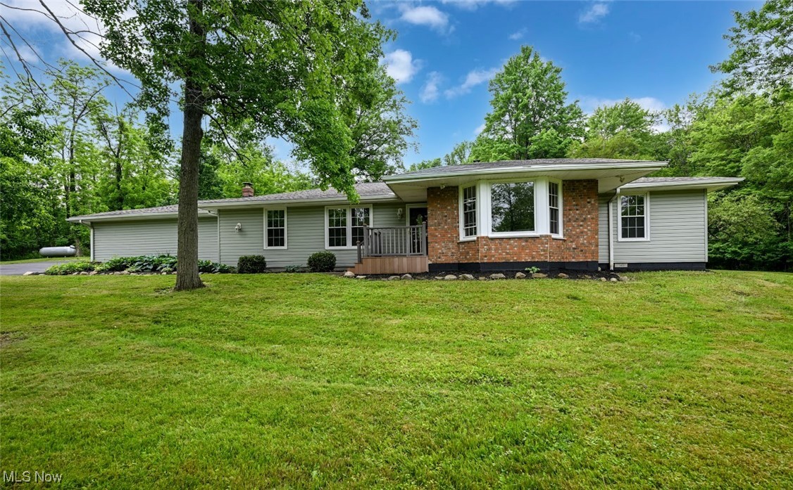 Country paradise! Beautifully updated 3-bedroom, 2-full bath ranch home situated on 3.5+ acres of wooded land in scenic Medina County. Completely gutted and fully renovated in 2006, featuring a stunning cherry cabinet kitchen with built-ins, granite countertops, peninsula, and pass-through. Remodeled tile bathrooms also include granite counters. Home boasts solid oak 6-panel doors, Andersen patio doors, new siding, updated electric, plumbing, and windows (2006). Spacious living room with bay window and stone surround fireplace. Rear walls of glass overlook the patio and firepit, offering serene woodland views and seasonal blooms visible from the kitchen, family room, and sunroom. (2025) updates include tear-off roof, asphalt upper driveway, stainless steel appliances, new carpeting, luxury vinyl plank flooring, fresh interior paint throughout (walls & ceilings), and a crawlspace encapsulated with dehumidifier (included). Additional updates: 2020 hot water tank and 2016 boiler. Ceiling fans in multiple rooms. All you need to do is move in and enjoy. Just 5 minutes from downtown Medina, shopping, schools, and hospitals. Extremely private setting. Property is offered AS IS.