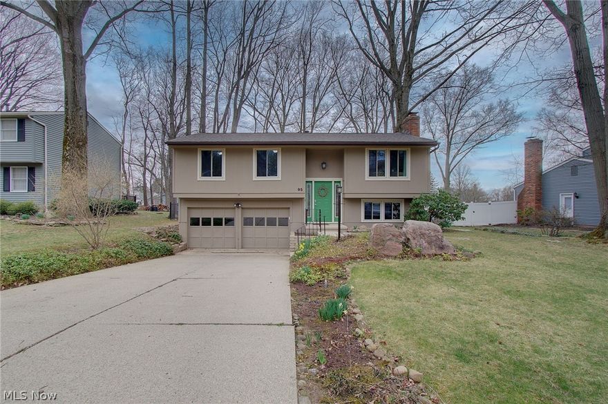 Welcome home...to this beautiful bi-level set on a large, private, fully fenced, park-like yard filled with mature trees, winding rock paths, flowering shrubs, and an abundance of perennial plants...perfect for relaxing or entertaining outdoors. Inside, an open-concept floor plan offers 1370 square feet including 3 spacious bedrooms and 2 full baths. A welcoming foyer with newer flooring and updated stairs and railing lead into the main living area, highlighted by soaring cathedral ceilings and great natural light. The updated, eat-in kitchen features a bright skylight, quartz countertops, laminate flooring, and includes all appliances. The dining area opens through a sliding door to a 12x18 deck with a safety gate at the top of the stairs which is ideal for pets, kids, and for outdoor gatherings. A generously sized living room completes the main level. All three bedrooms feature laminate flooring and share an updated main bath with skylight, solid surface counter, and ceramic tile flooring. Abundant closet space is found throughout the home. The lower level offers a comfortable family room with laminate flooring and a brick fireplace with gas insert. A utility room with ceramic tile flooring includes both the laundry area and an additional full bath. Attached 2-car  garage with new door openers. Very well maintained with neutral decor throughout! Mechanical updates include: roof/gutters/downspouts/fascia (2020), hot water tank (2021), and A/C (2018). Enhanced cable and internet options (coaxial, CAT5, plus attic digital antenna) provide modern connectivity. Fantastic location close to schools, shopping, restaurants, parks, the Summit County Metroparks Hike & Bike Trail, and the Stow-Munroe Falls Public library. This one is ready to just move-in and enjoy...schedule your private showing today!