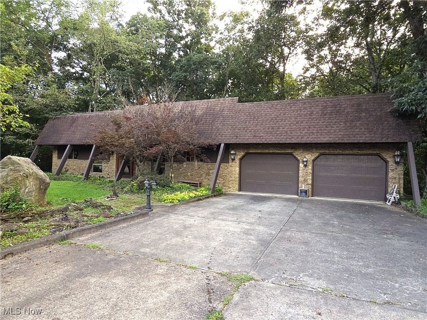 One of the most unique and original homes in Guernsey County just hit the market. Custom built in 1980 by Gerry Frencik. 3.684 acres, all wooded. includes a four bedroom home, with two baths, a two car attached garage and a three car 38' x 32' detached garage. Great room with stone waterfall and fireplace. Large wooden decks on rear of the home. Anderson Thermopane tinted windows, Mahogany hand carved front door, laundry chute, all cedar closets, walnut kitchen cabinets, 2x6 walls, R25 insulation R50 in the ceilings, 8' circular spiral staircase leading downstairs to the great room, interior wood box, wet bar seats six comfortably. All new stainless steel appliances, new metal roof, septic pumped in 2024, all electric, AEP bill runs $110-$230. leaded hot water tank, new metal roof on garage. Owner does not own mineral rights. This is a must see one of a kind. This property sells "as is".
