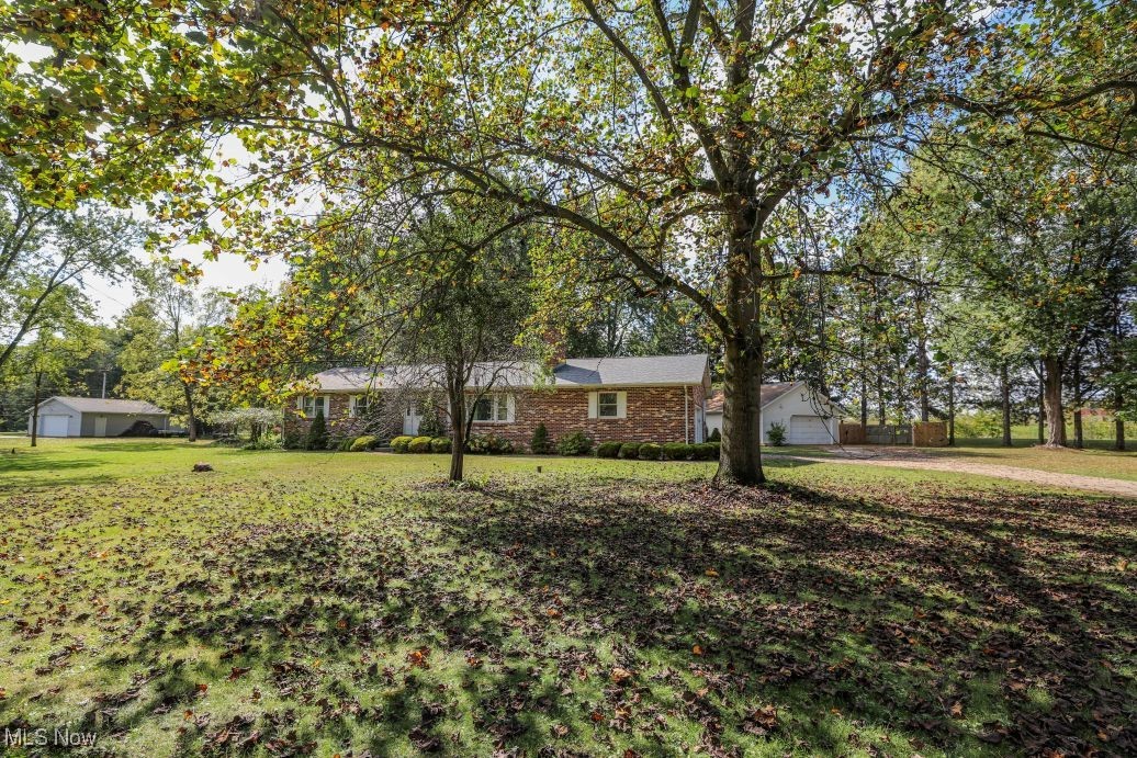 Nestled on a private, treed lot in the heart of Ravenna Township sits this charming, one-owner brick ranch that offers 1,656 sq. ft. of comfortable living space. Featuring 3 spacious bedrooms, and 2 bathrooms including the primary suite with an en-suite bathroom, this home is perfect for both relaxation and entertaining.
The large eat-in kitchen is ideal for family meals, while the living room with a cozy fireplace provides a perfect space to unwind. The 4-seasons sunroom is perfect for lounging with family or friends and provides year-round enjoyment. The finished basement adds valuable extra space with a large rec room, and office/ playroom, that could be used as a 4th bedroom to suit your needs.
Outdoor Amenities include a 2-car attached garage, large deck for outdoor relaxation, and 3 beautiful acres of private grounds that provide a tranquil parklike setting for outdoor activities and fun. A heated 28' x 38' detached garage with water, separate electric panel, and a 220-volt outlet perfect for hobbyists. A 17' x 31' barn with loft that offers ample storage, along with two additional storage sheds and a convenient 11' x 17' pole building for all your tools and equipment. Additionally, there is a party pavilion with a fireplace that provides the perfect setting for gatherings, rain or shine.
Located just minutes from all major highways, downtown Ravenna, NEOMED, downtown Kent, and Kent State University, with easy access to the Portage County Hike and Bike Trail right next door!
Recent upgrades include a new roof (3 years), a 2-year-old Generac generator, a 200-amp electrical panel (2 years), new AC (2-3 years), dishwasher (3 years), and a recently updated outside electric mast and meter (less than a year old).This home has been lovingly maintained and is ready for its next owner. Don't miss your chance to own this rare gem in a highly desirable location!