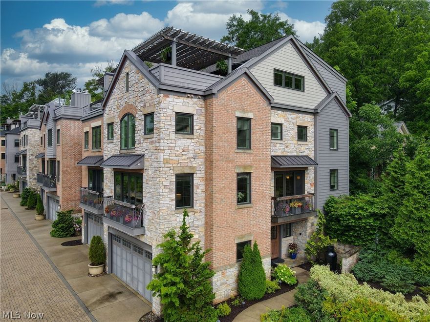 Stunning most desirable end unit River Walk Townhome! The brightest and lightest unit with walls of windows on each level and spectacular rooftop balcony overlooking the Village of Chagrin Falls! Inviting side entry that leads to the first floor spacious laundry/mudroom equipped with plenty of extra added storage and access to the elevator taking you to all 4 floors and the 2 car attached garage. The 2nd level features an open layout complete with wide plank wood flooring, great room with beamed ceiling, 2017 added fabulous redwood mantle and stone front fireplace and built in cabinetry. The gourmet kitchen complete with center island, breakfast bar, granite counters, designer backsplash, spacious pantry, and stainless appliances including wine fridge. The 3rd level boasts a wonderful master suite with large walk in closet and glamour bath with oversized shower (steam added in 2017) separate soaking tub and large double sink vanity. 2nd full bedroom and bath on the 3rd floor. The 4th l