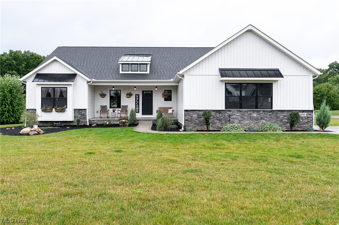 Welcome home to this beautiful custom-built Grisez 3 bedroom, 2 bath split ranch home in Hartville! Step inside the front door and enjoy the open-concept, rustic farmhouse main living area with distressed wood beam accent and vaulted ceiling. The great room boasts natural lighting and has gas fireplace with gorgeous stone surround and distressed wooden mantle. The kitchen has quartz countertops, walk-in pantry, stainless steel appliances, and a massive island with farmhouse sink, pendant lighting, and additional seating. The dining space is large, open and ready for entertaining. Off the dining space is a patio door that leads you to a 13x16 covered porch with recessed lighting and outdoor fan. Additional outdoor living space includes a flagstone patio with fire pit and covered front porch. The large primary bedroom is private with attached bath with dual sinks, quartz countertops, tile walk-in shower and 11x16 walk-in closet. Laundry room has large stainless steel utility sink, cab