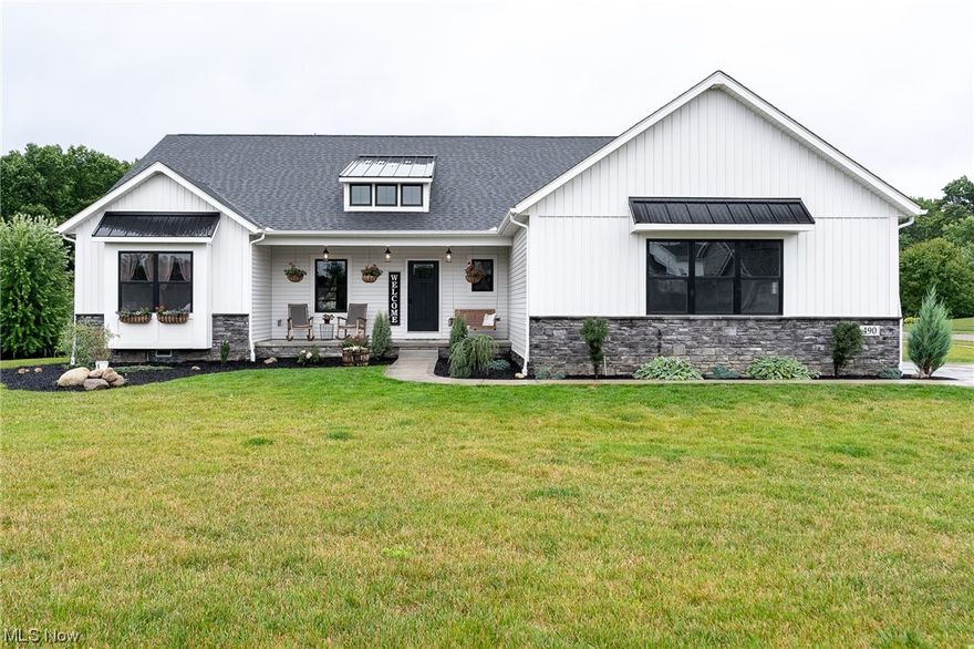 Welcome home to this beautiful custom-built Grisez 3 bedroom, 2 bath split ranch home in Hartville!  Step inside the front door and enjoy the open-concept, rustic farmhouse main living area with distressed wood beam accent and vaulted ceiling.  The great room boasts natural lighting and has gas fireplace with gorgeous stone surround and distressed wooden mantle. The kitchen has quartz countertops, walk-in pantry, stainless steel appliances, and a massive island with farmhouse sink, pendant lighting, and additional seating. The dining space is large, open and ready for entertaining.  Off the dining space is a patio door that leads you to a 13x16 covered porch with recessed lighting and outdoor fan. Additional outdoor living space includes a flagstone patio with fire pit and covered front porch. The large primary bedroom is private with attached bath with dual sinks, quartz countertops, tile walk-in shower and 11x16 walk-in closet. Laundry room has large stainless steel utility sink, cab