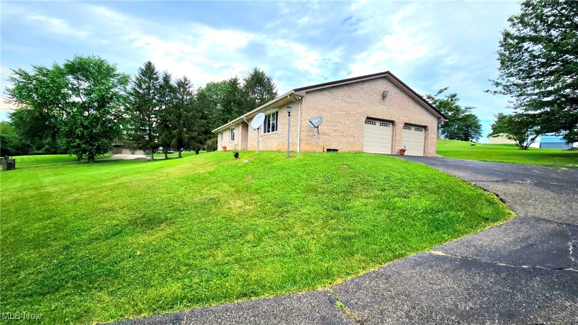 This beautiful brick ranch home is situated on a full country acre with mature trees and plenty of yard and field areas for outdoor entertainment or play. Enjoy easy living in this updated one-story space with one step into the back door. With 2012 sq ft all on one floor, this spacious house has a space for "everyone and everything". Avoid the weather by using the oversized 2-car attached garage with newer doors. While currently set up as a 3-bedroom home, it would be very easy to adapt this home to a 4-bedroom for larger households. Bring the outdoor beauty inside with new picture-sized double-paned windows in almost every room in the house. Bright airy rooms bring cheer to your household. Enjoy the cozy back living room with its lovely brick fireplace, while entertaining in the kitchen and dining room. Your living space can even expand onto the patio and yard through the newly replaced sliding glass door. Grab a fresh pear off your mature fruit tree. Create a more formal setting in the front living room with enough space for both entertaining and a home office. Have "peace of mind" by moving into a home where the "big-ticket" items have already been replaced! A new metal roof protects the entire package: including new 200 AMP Service and electric box; micro surge protection; generator-enabled switchboard pre-wired for a generator; doors; windows; flooring; paint; backsplash; chair-high toilets; and garage doors. The HVAC system features an electric heat pump and electric furnace that has recently been inspected. The central A/C unit is also updated. There is plenty of parking on the blacktopped driveway. Cell service and high-speed internet are available. A pull down ladder leads to additional storage space above the two car garage. Check out the virtual walk-through tour!
