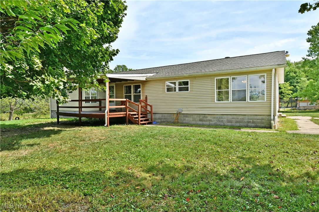 Get away from the hustle and bustle and enjoy the scenic rural views of this fantastic Vienna estate! This unique property includes a remarkable, 20 bay storage garage for all your potential needs or as a built-in business opportunity for rentals. Kick back on the covered front porch and ponder the possibilities as you peer from the leaves of the privacy veiled trees. Inside, the manufactured style ranch is set on a full foundation, adding to its available living space. A spacious living room enjoys hardwood styled flooring that continues throughout the first floor. Two sizeable bedrooms delight with large windows at the far end as they accompany a tastefully updated full bath and its glass tile accented vanity. Central dining spills into a must-see kitchen with a host of storage solutions and a pass -through serving window, brimming with country flair. A window-lined formal dining area makes every meal a visual treat as the fireplace laden family room looks on. The oversized master bedroom suite opens to an extravagant full bath with mirror lined, whirlpool tub, dual vanities and a stall shower. First floor laundry leads out into a rear sunroom and basement access.