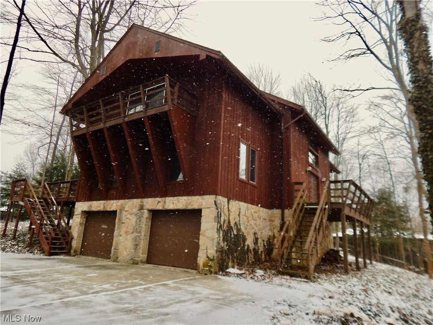 High atop Twin Lakes is a great opportunity to own this unique chalet with beautiful lake and wooded views! Cedarwood and river stone walls surround the exterior and complement the interior of this home. The interior also has fresh paint throughout and the neutral carpet has been professionally cleaned.  Upon entry, you are greeted by a foyer with a soaring ceiling. The main level has a bedroom with a full bathroom ensuite and a large grand room with a vaulted ceiling that features a stone fireplace. There is also a library with built-in bookshelves and a desk. A large kitchen/dining room area features panoramic views. The staircase leads you up to an open walkway overlooking the foyer on one side and the grand room on the other. A bedroom is on either side. One has a railing looking down upon the library, and one has a sitting room with a view of the great room. Both have added privacy doors. There is a full bathroom and a walk-in closet that complements the large closets in each bedr