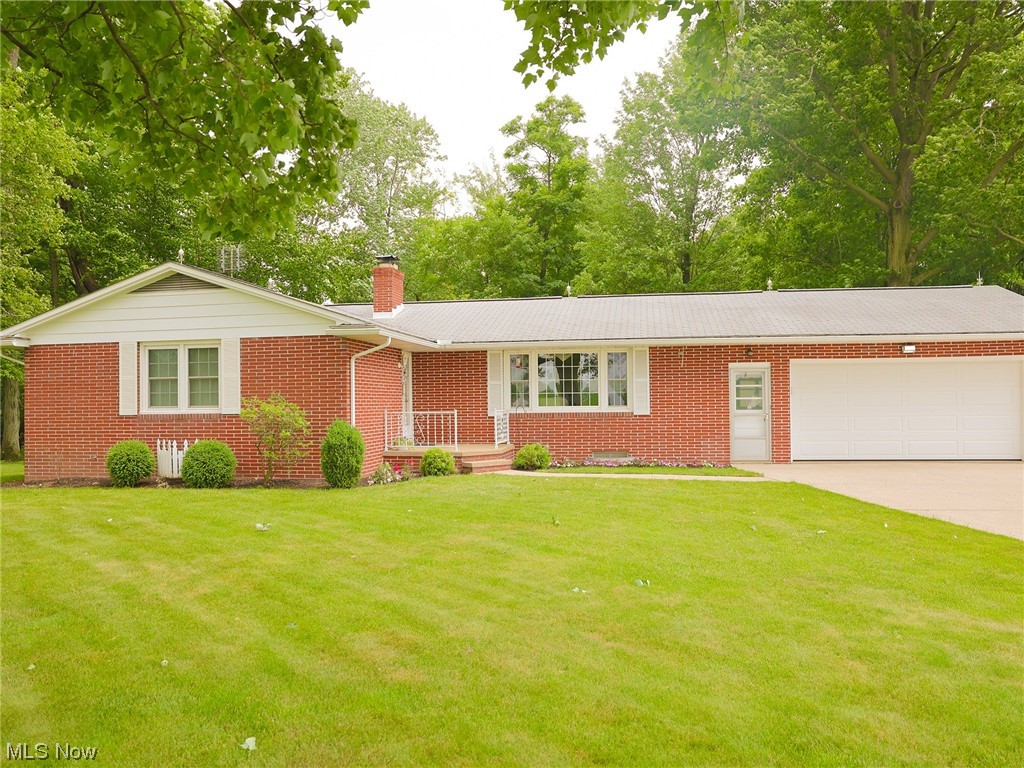 Discover the charm of this brick ranch home on the outskirts of Kidron, boasting a 32x52 woodshop. The main floor offers a living room, kitchen, and dining room with splendid views of the private, wooded backyard. Remodeled in 2013, the kitchen showcases custom cherry cabinets and stylish tile flooring. With 3 bedrooms and a well-appointed bathroom featuring a double-sink vanity, this meticulously maintained property ensures comfort. The attached 2-car garage and concrete driveway provide ample parking space. Enjoy the tranquility of the screened-in sunporch or relax on the deck, both overlooking the mature tree-shaded backyard. The walk-out basement can easily function as an apartment or in-law suite, featuring its own living room, kitchenette, additional bedrooms, and bathroom. The property is equipped with natural gas hot water heat and central AC for year-round comfort. A 15 KW Generac NG back-up generator offers peace of mind. The backyard showcases a heated and insulated 32x52 sh