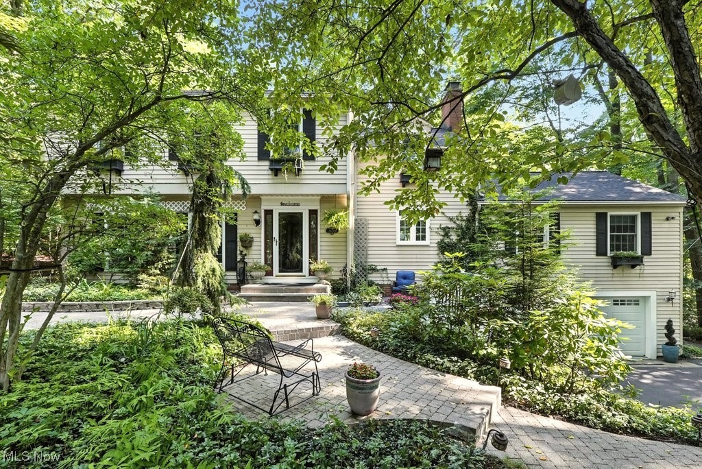 Nestled on a cul-de-sac in one of the most coveted corners of Willoughby Hills, this home is an experience, inside and out. From the moment you arrive, you’ll feel the call to slow down and unplug. Winding paths trace the perimeter of the property, each one inviting exploration. Whether you're wandering the trails, tending to the gardens, or gathered around the firepit as the sun sets, this is a setting that soothes the soul. Inside, the magic continues. The home has been thoughtfully updated with a designer’s eye. The heart of the home beats in the updated kitchen, where a cozy fireplace adds old-world charm to a modern space made for gathering. Make your way with a cup of coffee to the renovated sunroom (2023)—a light-filled masterpiece wrapped in windows, where the seasons unfold in full view, a front-row seat to nature’s rhythm. The oversized family room is another standout—anchored by yet another fireplace and lined with a full-length window seat with a cozy tree top view. Think game nights, movie marathons, and big celebrations full of laughter, this space can hold it all. The 1st floor office features handsome built-ins, perfect for focused work or creative projects. You’ll also find a generous dining room, complete with the home's 3rd fireplace, ideal for hosting everything from holiday feasts to intimate dinners. Upstairs, a primary suite with custom closet and an additional 3 large bedrooms share a large hall bathroom with dual vanities. Downstairs, the lower level expands your living space even further—with a full bathroom, an oversized laundry room, and flexible space ready for your vision. Outside, new hardscaping & landscaping (2024 & 2025) create seamless transitions between indoor and outdoor living, while the new whole-house generator (2022) ensures comfort through every season. There has been no detail overlooked. More than a house, it’s a gentle nudge to live more fully. To gather, to wander, to rest. A space that holds you—inside and out.