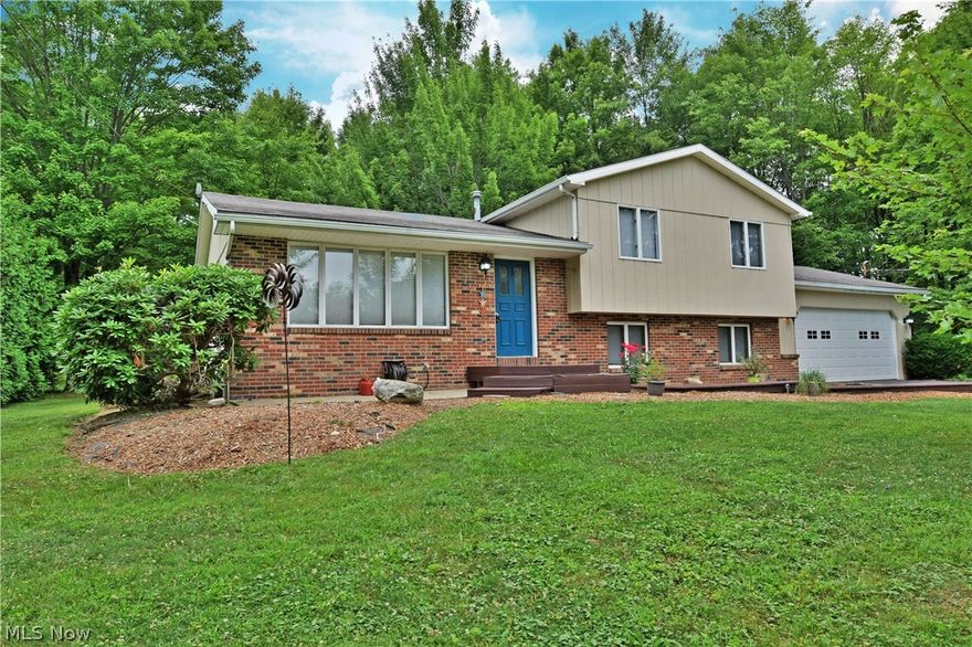 This stylish split-level home is just the one you’ve been waiting for! Nestled in a low traffic neighborhood, you’ll notice this residence right away with its floral landscaping and winding, stepped wooden walkway leading to the front porch. Inside, dark hardwood floors accent the gray walls and white trim work to create an inviting and modern appearance. A row of windows cast light into the spacious living room. A decadent dining area rests before a pair of French doors that lead to the elevated back patio, where a large deck steps down into an expansive back yard. The kitchen boats dark, cherry colored cabinets with high polished stone countertops that run between stainless appliances. Three upstairs bedrooms each offer ample living space, with a mix of both bright and subdued paint treatment above carpeted flooring. A full bath features a stunning double vanity with high sink fixtures. Large tile work fills the walls and shower, with slab style floor treatment. The lower level of th