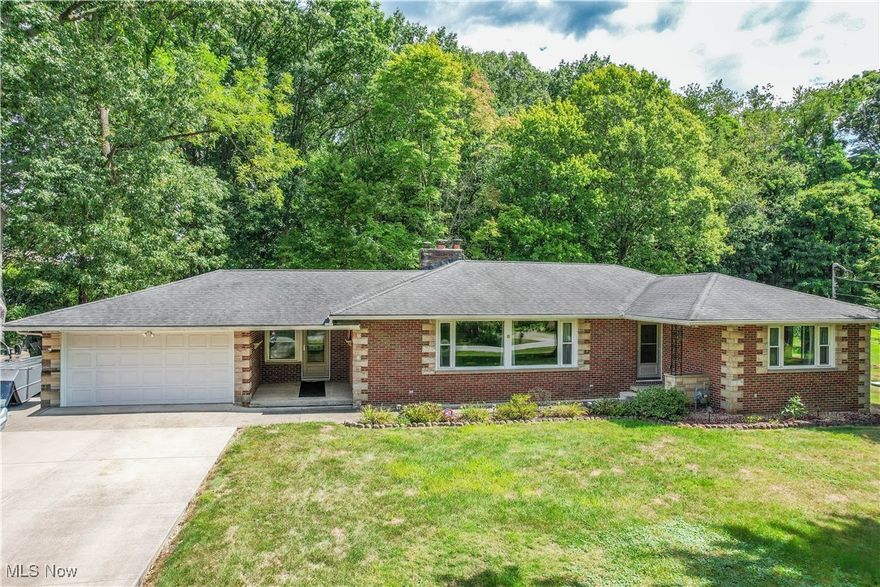 An amazing find! All brick ranch with 4 bedrooms, 2.5 baths, and nearly 3/4 of an acre of land. Step into a light filled living room with two large picture windows and a wood-burning fireplace with stone surround. The remodeled kitchen has space for dining, granite countertops, a tile backsplash, soft-close cabinetry, and stainless steel appliances including a wall oven and French door refrigerator surrounded by pantry cabinets. Down the hall are all four bedrooms with hardwood floors, including the primary suite with its own modern full bath and private access to the spacious deck and tree-lined backyard. The secondary bedrooms, one with knotty pine paneled walls, share an updated full bath with built-in linen storage. The waterproofed lower level adds a rec room with a convenient half bath, perfect for indoor gatherings. A mudroom connects the house to the two-car garage with a rear overhead door for easy backyard access and storage. Solid interior doors, new exterior doors, and updated furnace, A/C and windows make this home an easy choice. Schedule your showing today!