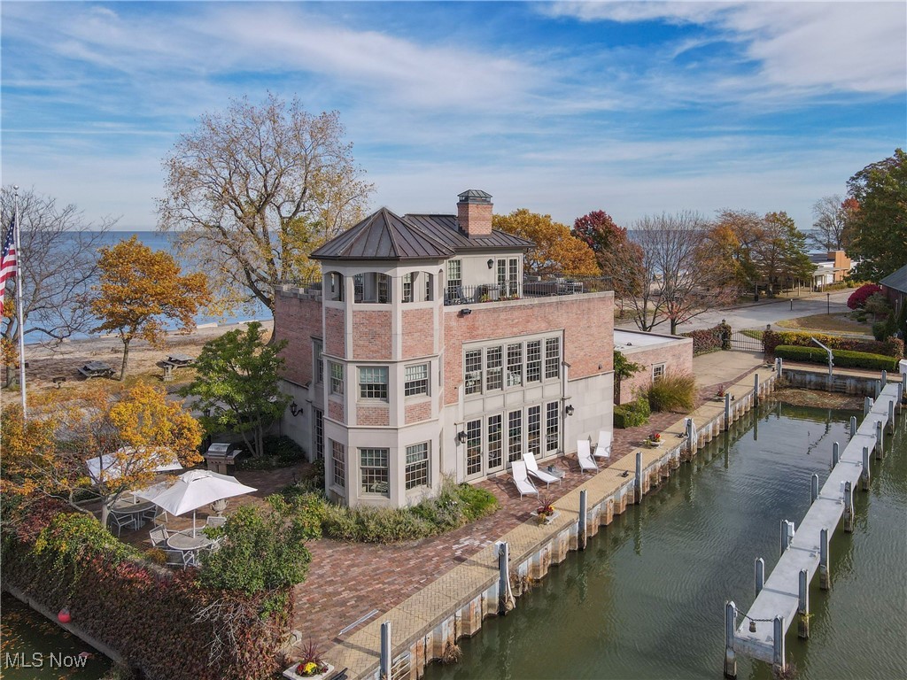 Perched elegantly in Cleveland’s coveted Clifton Lagoons, 830 Beach Road is a landmark residence of storied elegance and architectural sophistication, its commanding presence matched only by the unobstructed views of Lake Erie. This extraordinary home, steeped in history as it evolved from a boathouse to a celebrated private residence, has played host to some of the most illustrious figures in American culture. The meticulous renovation by the current owner imbues the residence with refined grandeur, beginning with an exterior of hand-hewn stonework reminiscent of New York City brownstones, leading gracefully to the original hardwood door that opens to a world of timeless beauty. Inside, the first floor flows seamlessly, designed with an open-concept ethos that balances sophistication and warmth—from the welcoming sitting room to the spacious dining area, chef’s kitchen, and light-filled living space framed by walls of windows that reveal the lagoon and views of the water. The second floor unfolds with serene, light-drenched spaces, including a guest room with hall bath and a luminous office offering panoramic water views, all culminating in an owner’s suite that has refined finishes, wood burning fireplace and sweeping lake vistas. Crowned by a third-floor penthouse style sun room, the residence reaches its apex with a sanctuary of wraparound windows and a rooftop deck that provides a 360-degree panorama of Lake Erie. Entertain or simply relax, enjoying nonstop boat and sailboat activity as a backdrop. Take full advantage of the lake with a direct boat slip next to the home! Included is a separate, buildable parcel and second boat slip. 830 Beach Road is more than a residence; it is a distinguished piece of Cleveland’s history, masterfully renewed, and poised to offer an unmatched lifestyle on the lake’s edge.