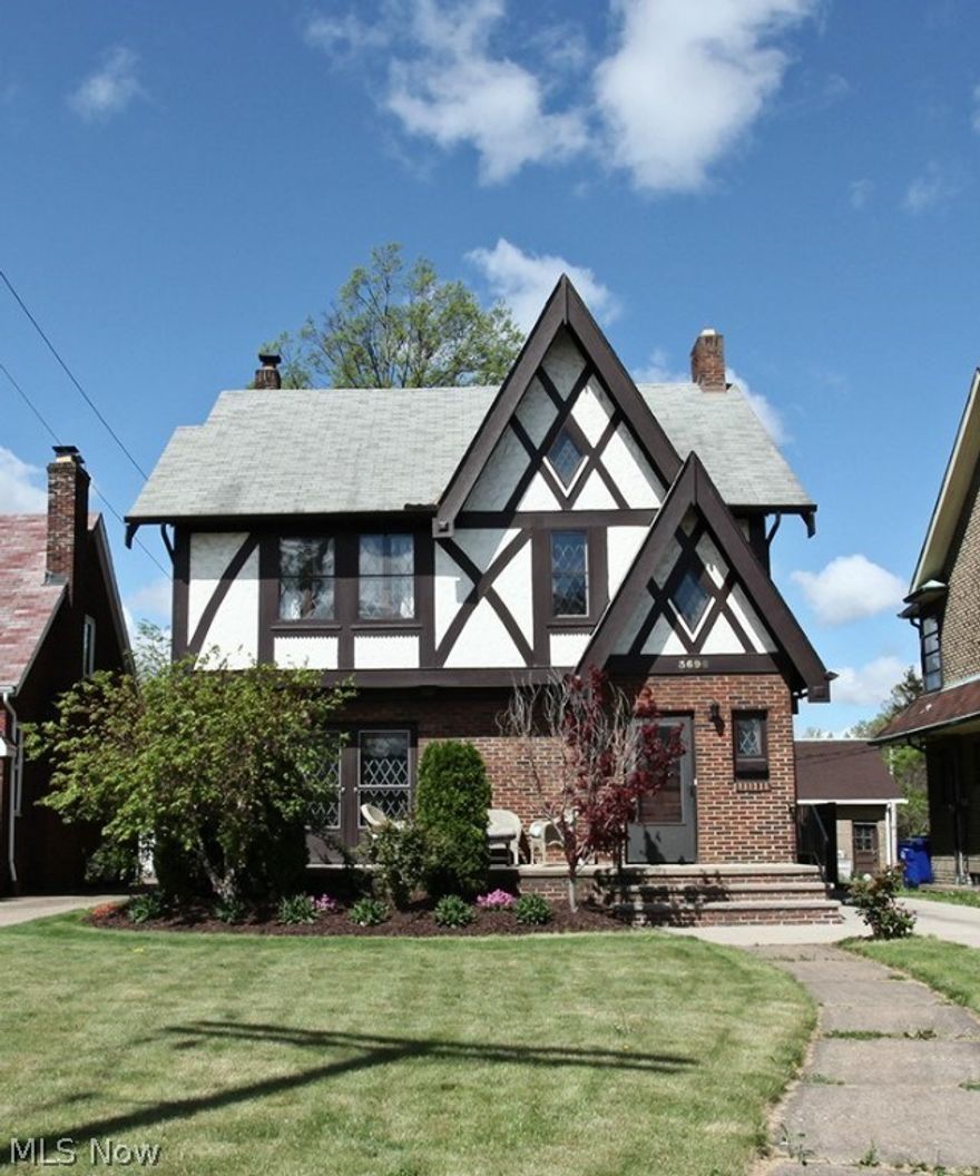Gorgeous Tudor style colonial full of character & charm! The leaded glass windows in this home are just amazing!! All other windows are updated. Gleaming hardwood floors throughout! Walk into the enclosed foyer w/a closet & a french door leading into the living space. The large living room features a beautiful fireplace w/ built-in lights, ceiling fan & beautiful archways.  The formal dining room has beautiful built-in cabinets, & a set of gorgeous french doors that lead to the lovely front porch. The kitchen offers plenty of cabinet & counter space, a nice glass tile back-splash & a lovely breakfast nook w/views of the back yard. 1st floor half bath is completely updated. Upstairs are 3 nice size bedrooms, all w/ ceiling fans, the full bath with subway tile that's in pristine condition & the enclosed porch. The spacious attic has great potential to be finished into a cool office, play room or additional bedroom. The full basement has a nice rec room w/stone fireplace & built-in shelvi