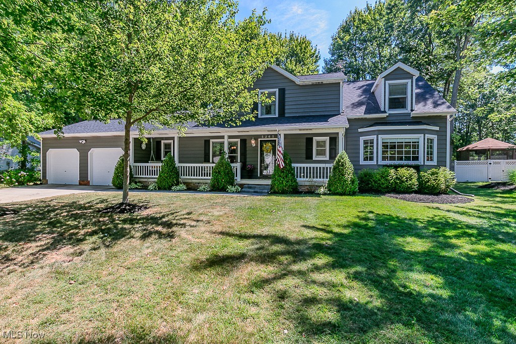 Welcome to 5265 Lenore Drive — an expansive and beautifully designed four-bedroom, three-bathroom residence offering over 3,200 square feet of living space in the highly desirable Woodhill subdivision of Mentor. Set on a serene and private ¾-acre tree-lined lot, this home impresses from the moment you arrive, with a stamped concrete walkway, a covered front porch complete with swing, and an oversized TimberTech rear deck (2024) overlooking a sparkling 16’x32’ Doughboy pool and a step-down paver patio ideal for outdoor dining, entertaining, or peaceful retreat. Inside, gleaming hardwood floors guide you through the foyer and into the heart of the home — a breathtaking 500 sq. ft. great room featuring soaring vaulted ceilings, custom picture windows, an oak-trimmed wood-burning fireplace, and built-in shelving, all overlooked by a second-floor loft. The spacious eat-in kitchen blends beauty and function with updated stainless steel appliances, ceramic tile backsplash, modern fixtures, and a breakfast bar that seamlessly opens to the great room. A formal dining room adds to the home’s entertaining appeal, while the sought-after first-floor primary suite includes a walk-in closet, a secondary closet, crown molding, and a remodeled en-suite bath (2024) featuring a soaking tub and dual vanity. The suite also includes a private office or nursery space. The convenient first-floor laundry room and walk-in pantry further complement the home’s highly desirable one-floor living layout. Upstairs, three additional bedrooms share a full bath with double vanity, all accessed via a charming lofted hallway. The finished lower level is an entertainer’s dream with a large recreation room anchored by a gas stone fireplace, plus utility access and two sizable storage areas for all your seasonal and household needs. New Roof in 2023. New carpet Great Room 2025. This home truly offers a rare blend of comfort, functionality, and charm in a coveted Mentor neighborhood.