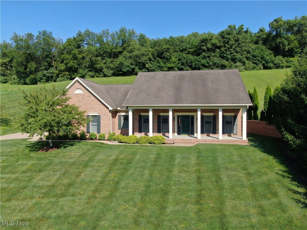 Residing high above it all with Tremendous Views, is this 3BR-3BA Colonial style, all brick home on 1.67 acres in town Millersburg! Located next to many major conveniences, this approximately 4,010 sq. ft. finished home was built in 2006 by Dave Croft Construction, and exudes Style and Elegance, coupled with Warmth throughout. Enter the front door and you will be impressed immediately with the quality which greets you, evident in the beautiful, raised panel wainscotting, crown molding, and arched wood cased opening into the formal dining room. The central first floor encompasses the heart of the home with an open kitchen/living room area. Mullet cabinets abound in the fully equipped kitchen complete with a breakfast bar overlooking the eating area, and living room with built in shelving flanking the gas fireplace. A double set of French doors will lead you from the eating area/ living room, out to a nice sized tile floor sunroom. The south wing contains, a full bath, shared by the 2 bedrooms, both with high end woodwork and molding as well as ample closet space. The north wing contains a nice sized laundry room with sink and cupboards, hall storage closet and the private Main Bedroom with the walk-in closet contained in the ensuite bathroom featuring a double vanity, water closet, soaking tub and separate shower. Head on down to the lower level and you will find a Massive finished family/rec room, another large, finished area which lends itself to a variety of uses based on your needs. There is also an oversized full bathroom and the unfinished area which contains the furnace/hot water heater and has built in shelving with plenty of storage area. Complete this Impressive package with a private back stamped concrete patio, a spacious 2 car garage, finished in knotty pine with a small workshop room, and a Heated concrete driveway. Truly an Impressive home for those seeking Elegance coupled with Warmth!