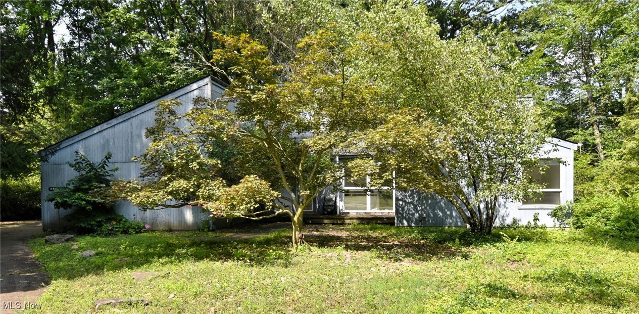 Step into this fabulous contemporary 4 bedroom home, brimming with potential and filled with natural light from walls of windows that overlook a beautiful semi-wooded lot. The expansive living and dining area features soaring ceilings, a fireplace, creating an open, airy space perfect for entertaining. The bright kitchen offers ample counter space, white cabinetry, a breakfast nook with a skylight, and large windows. The main level includes two bedrooms and two full baths, including a spacious owner's suite, plus a guest powder room and a large first-floor laundry room. The lower level features additional bedroom , a full bathroom and a flex room, ideal for an office, media room, or workout space. While this home needs updating and TLC, it offers a wonderful layout, great bones, a newer furnace and hot water tank, and an attached two-car garage, making it a fantastic opportunity to create your dream space in a serene, natural setting. Centrally located close to freeways, shopping, restaurants, grocery stores, University Circle and hospitals. Home warranty offered.