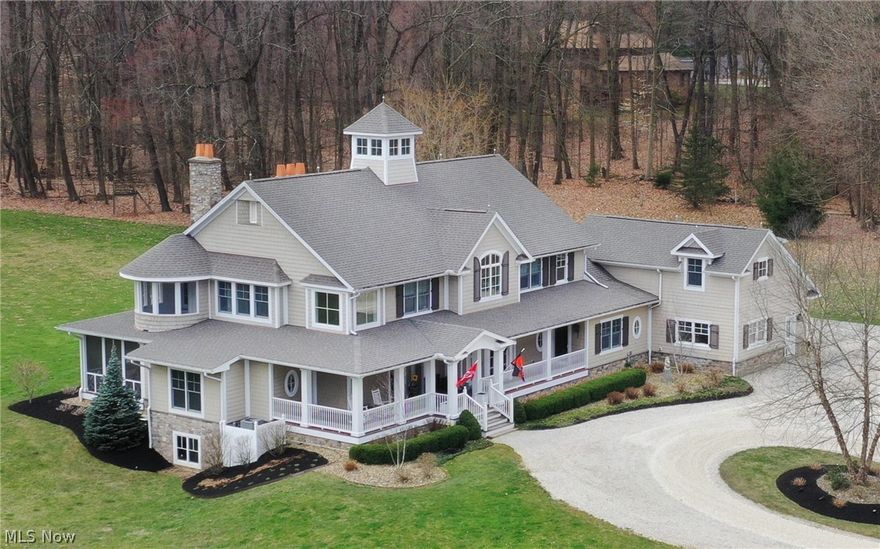 Spectacular manor estate situated on 13+ wooded, rolling acres in Bath Twp. presents superb craftsmanship and brilliant appointments throughout.  This tranquil setting boasts an extraordinary lifestyle and convenience all in one location.  Front entry leads to gracious foyer with arched ceiling and walk-in closet. Exquisite formal dining room features crown molding, hardwood floors, and 2 sets of French doors to covered porch. Engaging great room highlights beamed ceiling, stone fireplace flanked by French doors to rear patio, and wall of built-ins.  First floor library features a gas starting wood burn fireplace, dental crown  molding, built-in bookshelves, and pocket door to parlor w/wet bar, frig, and access to screened porch. State of the art kitchen offers SS appliances including 6 gas burners, Wolf dbl ovens, dbl DW, Subzero full size side by side refrig/freezer, center island/br bar, and hall of pantry closets.  Sizeable 1st and 2nd floor laundry rooms.  Conveniently located are the butlers pantry and 2 half baths. Two staircases to 2nd floor and lower level.  Luxurious, vaulted owners suite boasts fireplace, glamour bath w/jetted tub and walk-in shower w/dual sprays, bedrm sized closet, and French door to balcony porch.  Three add'l bedrooms, one w/ jack-n-jill bath and one ensuite, complete the 2nd level.  Multi-purpose room on third floor w/skylights & stairs to observation perch.  Expansive bonus room affords add'l living space.  Fabulous LL family room w/stone fireplace, full bar, eating area, office, and full bath. This home showcases the perfect blend of upscale amenities and traditional finishes. Front wrap around covered deck. Horse barn w/stalls.  Invisible fence and dog run.  Screened porch off parlor.  Inviting outdoor covered porch w/ fireplace and gas heater. New roof on the house and the barn in 2023. New roof Nov. 2023, FF washer/dryer <2 yrs, 2nd floor washer/dryer <5 yrs, on demand hot water heater 2 yrs. old.  Revere schools.