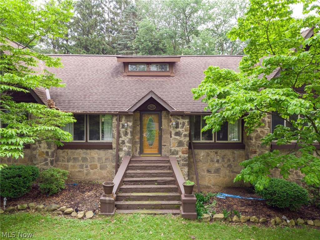 209 E. Park Ave. Barberton OH 44203 Beautiful natural stone Cape Cod 3 to 5 bedroom & 3 bathroom home 2 car garage 1st floor living at its finest! Stone exterior is absolutely beautiful! Grand Front Entry w/ wide stairs & newer dimensional shingle roof, mature landscaping, planting beds & ornamentals is just stunning.... But just wait until you walk inside this gorgeous home, awesome wood floors throughout w/ wood accents, original interior doors, exposed wood & trim! Grand Living Room features an eye catching stone surround fireplace w/ wood burner box & builtin wood cabinet, exposed wood ceiling accents trusses & wood flooring from above to create a stunning ceiling! Plenty of room for multiple seating areas & built in shelving, original interior doors, fantastic layout! The well laid out kitchen also has wood flooring with U-shape design for awesome flow & dining, plenty of counterspace including builtin huge cabinet as a bakers rack or bar! 3 bedrooms on ground floor feature 2 Master Bedrooms, one w/ actual private full en suite bath currently being used as a home office as well as 2nd Master in the rear of home w/ mirrored closet doors & private hall leading to the 2nd full bathroom w/ granite countertop & brushed stainless faucet, wood accents and plenty of storage. 3rd bedroom is on front corner of home w/ natural light from newer replacement vinyl windows throughout the home! 2 Bonus Rooms on 2nd floor use as 4th & 5th bedrms or play rm, media rm, etc. 1st flr Laundry
