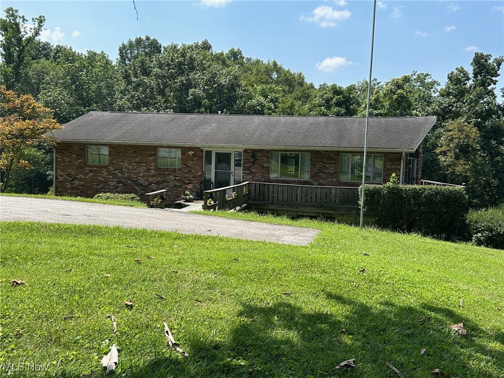 Custom One-Owner Home on 1.4+/- Acres, first time offered on the market! This unique property offers privacy and space just minutes from all conveniences. Step inside to discover a one-owner, custom-built home featuring a stunning wall of windows and soaring cathedral ceilings in the living and dining areas, filling the space with natural light. The spacious eat-in kitchen features stainless steel appliances, an island, a pantry, a custom sink area with a view in every direction, and a sliding door that leads to the expansive wrap-around deck—perfect for indoor-outdoor living. The main floor features three bedrooms and a full bath. At the same time, the fully finished lower level features a large recreation room with sliding doors, an office area equipped with built-in bookshelves, two additional bedrooms, and a full bath. A secret room with a vault door adds a special touch of character and security. The built-in single-car garage is complemented by a 56’x28’ detached two-car garage, large enough for 4 or 5 cars, with a workshop area and dual lean-tos—ideal for hobbies, storage, or small business needs. With a few personal updates, this home holds incredible potential. New HVAC 2021. A rare opportunity in a private setting that’s still close to everything!