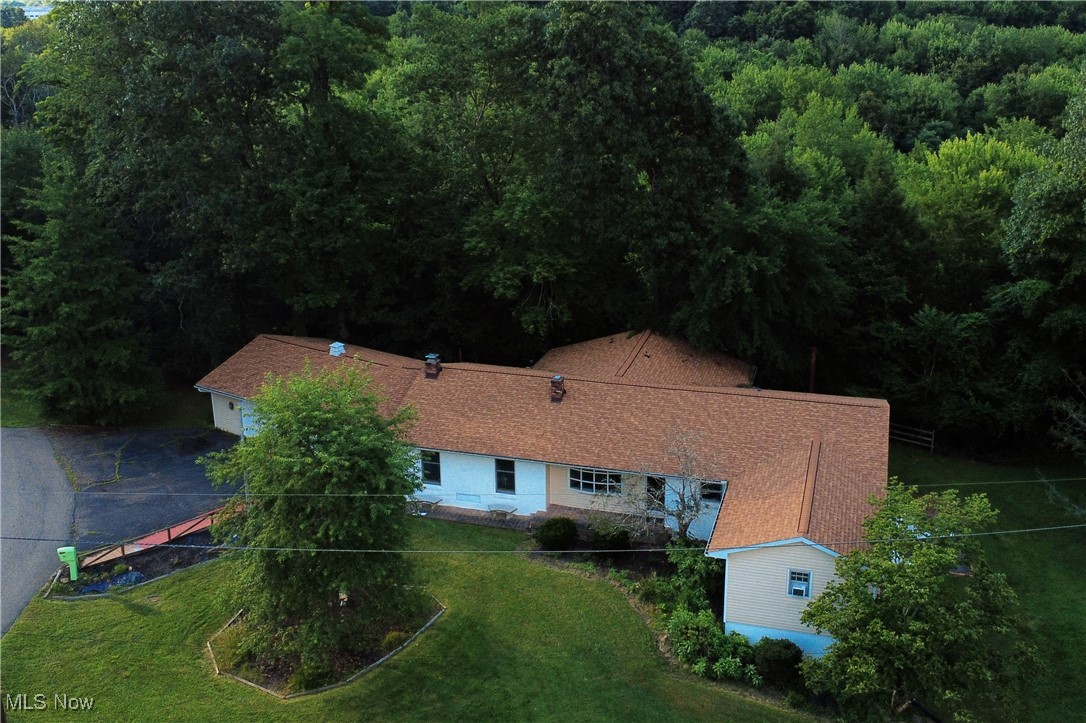 Tucked away at the end of a quiet cul-de-sac in the East Muskingum School District, this lovingly maintained and quality-constructed ranch offers incredible space, character, and serene wooded views overlooking a peaceful creek.
With 4–5 bedrooms, 2.5 baths, and over 4,000 sq. ft. of finished living space (2,496 sq. ft. on the main level and 1,606 sq. ft. in the walk-out lower level), this home is truly one-of-a-kind. The layout is both open and versatile, designed for comfortable living and gracious entertaining.
The heart of the home is a 20.9' x 19' great room featuring a fireplace flanked by custom built-ins, adding a classic Williamsburg touch. The formal living and dining rooms exude warmth and tradition, with the dining room showcasing a charming built-in corner hutch. The country-style kitchen is fully appliances and spacious, perfect for family meals or holiday gatherings.
Enjoy two wood-burning fireplaces, original hardwood floors in several rooms, and abundant natural light throughout. A private office provides space for work or hobbies.
The walk-out basement includes multiple bonus rooms, a second family room with a wood-burning stove, a fifth bedroom, full bath, laundry area, and extra flexible space—ideal for guests, recreation, or multi-generational living.
Outside, relax on the multiple decks and outstanding patio areas, all overlooking a wooded ravine and gentle stream. The oversized 2-car garage includes ample storage and a covered breezeway connecting to the home—perfect for rainy-day arrivals or weekend projects.