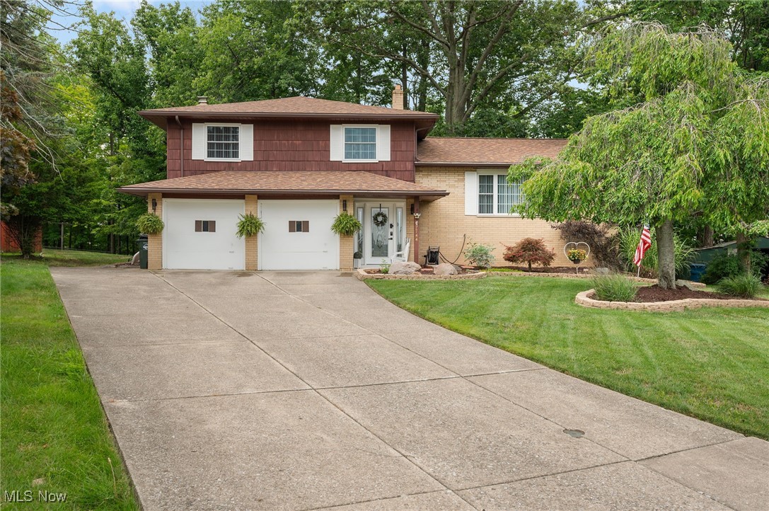 Tucked away on a quiet residential street, this beautifully maintained split-level home offers over 2,000 square feet of versatile living space with 4 bedrooms, 1 full and 1 half bathroom, and an attached garage—all situated on a generous lot. Step through charming glass-detailed doors into the welcoming family room, where plush carpeting, a cozy fireplace set against a brown stone accent wall, and sliding glass doors to the backyard create the perfect setting for relaxation. A convenient half bathroom completes this level. Upstairs, you'll find a light-filled main living area that seamlessly connects the kitchen, dining, and living rooms—perfect for both everyday living and entertaining. The kitchen features ample cabinetry, stainless steel appliances, and a central island ideal for quick meals or casual gatherings. The dining area is bright and airy, anchored by a large window, while the adjacent living room offers soft carpeting, a picture window, and a second fireplace that adds extra charm and warmth. The top level includes four spacious bedrooms, each with its own peaceful view, and a full bathroom to serve the space. The lower level expands the home even further with a dedicated recreational area and a laundry room—offering flexible space for hobbies, workouts, or storage. Outside, enjoy a huge backyard framed by mature trees—complete with a patio and a relaxing hot tub, perfect for entertaining or unwinding after a long day. Whether you're hosting a barbecue, gardening, or soaking under the stars, this outdoor space is a true retreat. The attached garage and extended driveway provide ample parking and everyday convenience. This home offers the perfect blend of comfort, space, and location—ideal for a growing household or anyone seeking room to spread out. Don’t miss your opportunity to make it yours!