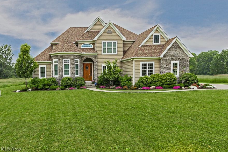 Simply stunning, this magnificent colonial awaits you in the Chagrin Valley. The two-story foyer greets you with inviting décor, opening up to the upstairs and great room. To the right of the foyer you will find a formal dining room with tray ceiling. The great room boasts a two-story stone fireplace and wall of windows. Off the great room is a beautiful eat-in kitchen featuring stainless steel appliances, Tuscan-style cabinetry, and breakfast bar. From the kitchen, step out of the sliding glass doors onto a flagstone patio leading to stone fire pit. First floor master suite extends into his/her walk-in closets with built-ins, glamour bath, and a huge glass shower. Another bedroom with full bathroom completes the main level. The second floor showcases a loft, as well as three more bedrooms, with one offering an attached bonus room. Absolutely fabulous custom-built lower level made for entertaining and recreation. Media room with tiered theater seating and 120’ projection screen. Separa