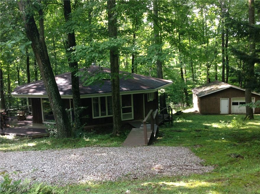 The back of these lots abutt the Black Diamond Golf Course. This is a smallish (1,063 sqft)  2 bedroom home with character on 4 Absolutely Gorgeous lots abutting the golf course. The home is octogon shaped with vaulted ceiling and lovely views over the wooded yard with tall mature trees. The floorplan is very open. There are 8-foot sliding doors leading to a private cement patio and Trex deck. The eating area has a large 5-panel casement window that is 8 feet across. The kitchen and bath(large) are original, but the setting is Spectacular.  At $117,500 at Lake Buckhorn on such a spectacular setting, this is a value worth improving to make it your own. There are skylights in both the Kitchen & Great Room. A woodburner is in the great room as an auxilary heat source. There is a 28 x 24 Detached Garage.