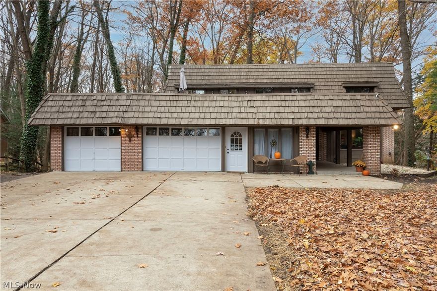 A PERFECT PLACE TO CALL HOME!!  This large Colonial has a contemporary style and modern vibe that makes it one of the more unique homes in this beautiful and sought after neighborhood. The spacious living and dining rooms have LVT flooring. The eat-in kitchen, with plenty of cabinets and countertop space is ideal for storage and meal prep. Just off the kitchen there is a family room with a gorgeous stone fireplace with access to the raised deck. Also, from the kitchen there is a great room with floor to ceiling windows that offer spectacular views of the wooded back yard. A half bath and office also located on the first floor. 3 good size bedrooms with large closets and the main bath are on the second floor. The large master suite features large dual closets, second floor laundry, en suite bath and access to an awesome roof top deck area. The lower level walk-out basement has an additional fireplace, and a kitchenette.