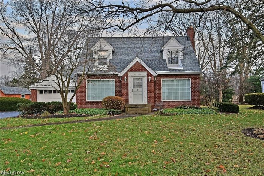 This stunning brick cape cod has all the right looks where it counts the most! An elegant outdoor appearance pairs the rich red brickwork with white trim. Well-manicured landscaping surrounds the property, following around back to a fenced in yard where a huge rear patio area is available. Inside the front door, massive lattice windows pour in natural lighting from each side as you face an ornate wooden staircase that matches the dark hardwood floor and white chair rail with finishing walls. Heavy crown and baseboard flow through each room, adding to the allure. A spacious living room presents an on-demand gas fireplace. Opposite, the decadent formal dining room shares views of the kitchen and frontal landscaping alike. A prominent center range juts from the adjacent wall, giving an old-world feel. Nearby, a converted sunroom makes for a fantastic family room area with its multitude of windows and skylights. Upstairs, three gorgeous bedrooms combine loft like ceiling architecture with