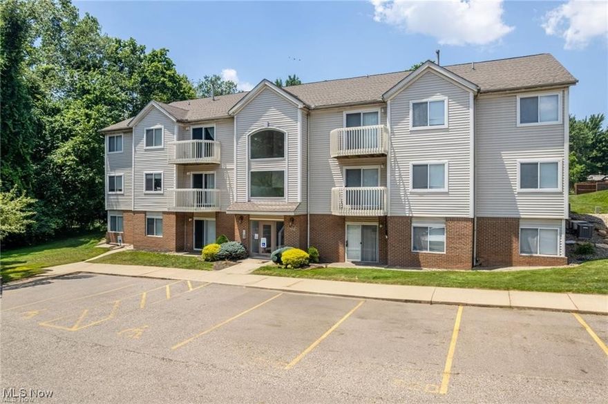If you're looking for a modern condo with just the right amount of space, this one should fit like a glove. Located in the Brookledge Commons of Cuyahoga Falls, this property offers you plenty of space to live, relax, and entertain without excess. From the first step into the living room, you'll enjoy modern comfort and functionality. Laminate wood floors run throughout for a cohesive space. Built in shelving and cabinets line the wall, plus a smart little wine fridge, maximizing every storage opportunity and keeping clutter at bay. Large windows let in ample sunlight, and the dining area has a sliding glass door that takes you out to a concrete patio. The back of the unit overlooks a lush tree line, where a whole menagerie of woodland creatures await. You'll often see deer relaxing in the grass and so many vibrant birds - it's the perfect spot to unwind. The kitchen is super-efficient, with gorgeous Kitchen Aide appliances, modern tile backsplash and open shelving in addition to plenty of cabinets. There is bar seating that connects you to the living area. For your evening retreat, the Primary Suite has a full bathroom with standing shower. There is a second bedroom and hallway bath, with freestanding soaker tub you'll want to climb on in. We know condos are great for low maintenance living, and this one serves up a community pool and workout room to use as well. Make your move fast! Gems like this don't last long.