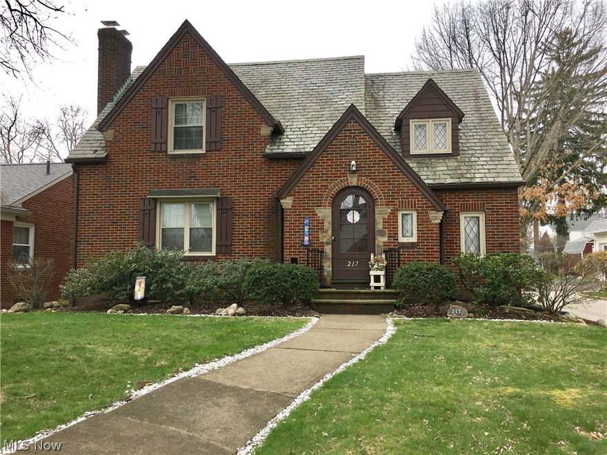 This lovely brick Tudor was built in 1940 and has the nostalgia of the grand yesteryears impact by the brick street and lamp posts.
Formal dining room opens from the French doors into the sunroom for relaxation. Enter thru the arched door into the foyer and large living room with a bay window and gas fireplace. Fully applianced updated kitchen with bar and stools. 2nd story offers full bath, master bedroom with hardwood floors and walk in closet, 3rd bedroom has carpet but hardwood floors underneath, 2 closets, walk in storage area with charming dormer with lead glass windows. Basement offers recreation room with wood burning fireplace, work room, storage room, laundry room and glass block windows. This home has beautiful updates. Beautifully landscaped yard with storage shed. This charming home will not last. 24 hr. notice to show.