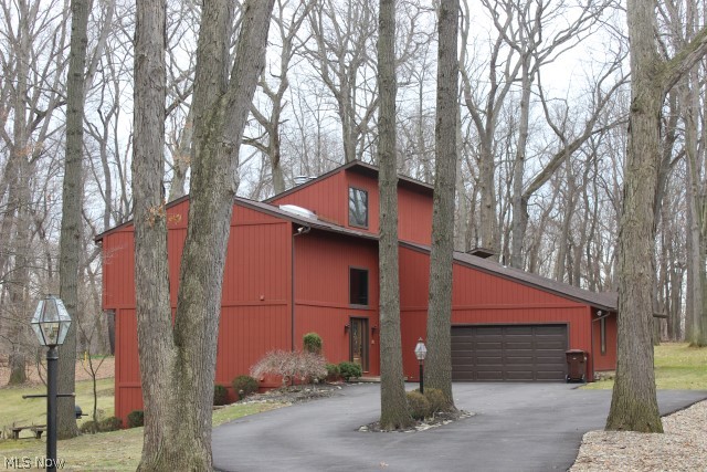Wow!! Outstanding 4 bedroom, 4 bath contemporary w/3 fireplaces on 1.06 acre cul de sac lot, approx. 3380SF including finished walk out lower level & 3 car garage (one side tandem)* 2 story entry w/beveled glass door & sky lights* Vaulted great room w/gas or wood burning brick fireplace, wood like laminate, sky lights, built in cabinet & atrium door to deck* Vaulted living room w/stove wood burning fireplace, newer Pella atrium door to balcony/3 season sun room & open to formal dining room w/slider to sun room- both rooms w/wood like laminate floor* 1st floor office & guest bedroom (bedroom w/private access to full bath)* 3 season sun room wrapped w/windows, wood like floor & access to partially covered deck* Kitchen w/ceramic floor, oak cabinets, island w/Jenn Air burner tops, double ovens, refrig & new dishwasher* Master bedroom w/walk out closet & private access to bath w/sky light* Rec Room w/conversation pit w/fireplace, wet bar & slider to brick patio* Oversized tandem garage w/