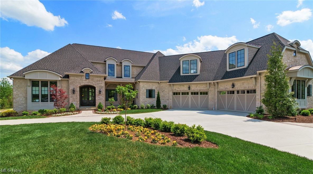 Buider's model now being offered for sale! 9,869 sq feet of finished living space includes almost 3300 sq feet on the lower level with walkout to multilevel paver patios, grilling area, and relaxing pond with a fountain. First floor Master suite, 3 bdrms on second floor and 5th bedroom on lower level. Full stone exterior with cedar and brick accents. Front and rear covered porches paved with bluestone. First floor offers 11ft ceilings, Award winning kitchen with cathedral ceilings, hand hewn beams, custom cabinets, leads to spacious prep kitchen with butcher block island, 2 separate office areas, large laundry room, kid's room right off kitchen can serve a variety of functions. Wide plank hand scraped solid Hickory floors on first floor great room and open dining area. Great mudroom leads to 4 car garage. Mudroom includes cubbies for organization and dog zone. Walkout lower level includes: Kitchen/bar, wine room, kid's play house, full bath, and fifth bedroom with buit in bunks, add