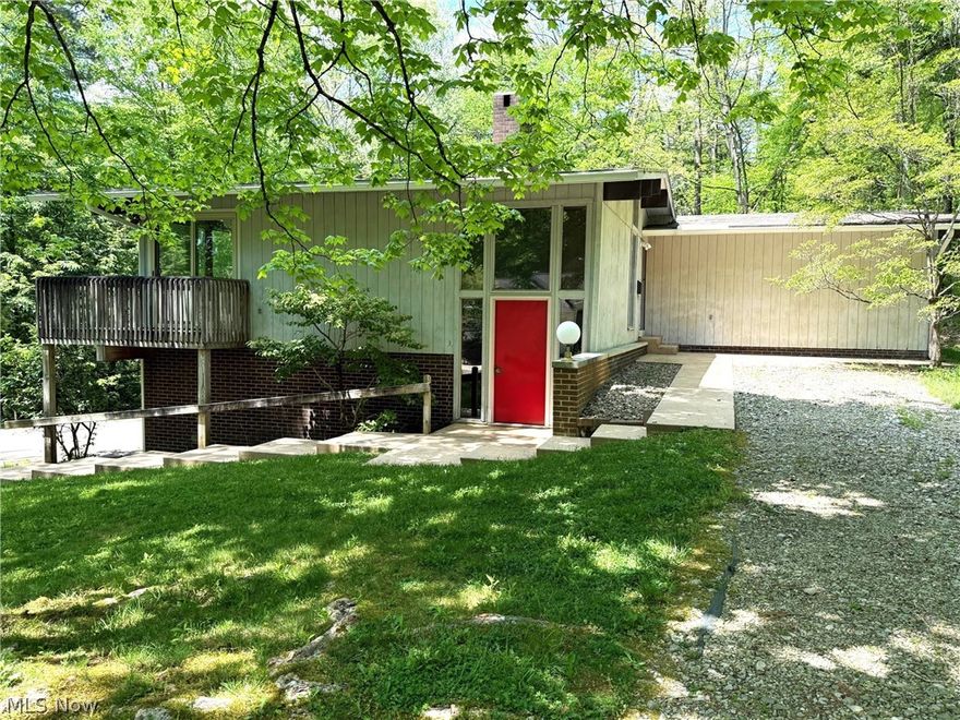 Located in an area of town that few even know exists, resides this One Owner, 3BR-2.5BA Mid-Century Modern style home on 2.7 acres.  Upon entering, the slate tile floor will lead you up to the first level.  A spacious great room with a floor to ceiling fireplace leads to the dining area, both with a full wall of windows overlooking the woods.  Tucked around the corner is the fully equipped eat in kitchen with nice cabinetry. Head on back the hall and you will find 3 nice sized bedrooms with full walls of closets, and a full bath with an adjoining half bath with a stacked washer/dryer. Meander back down to the lower level which contains the 2-car garage, a workshop area and a large family room with a freestanding wood stove.  There is also an indoor grill/bar area with a sink, perfect for entertaining.  Lead on and you will find another laundry/storage room with the 3rd bathroom.  In town, secluded location, and minimal yard upkeep. Check this one out!