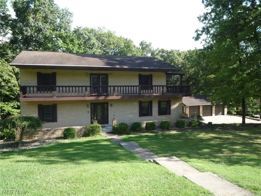 Lovely Brick 2 story home situated on a 1.5 acre wooded lot in the Ridgewood Heights of Belpre. If plenty of space is what you want, this is for you! The 1st floor features a marble floor entry, huge formal Living room, Family room w/ wood burning stone fireplace. Oak kitchen w/ solid surface countertops, Breakfast-nook, Formal dining room, den, laundry room and a full bath! There's also a 11x14 screened deck and 18x12 open deck to enjoy the wooded yard! The 2nd floor has a 8x18 landing w/ doors to a deck stretching the full front of the house. There are 4 bedrooms here. The Master is a spacious 18x15 with a stone wood burning fireplace, walk-in closet and access to the front deck. The Luxurious Master bath features a jetted soaking tub, double sink and glass walled walk-in shower. The walk-out lower level has a Rec-room, a 13x21 bonus room built as a hand-ball court, a Florida room w/a hot tub, and an oversized 24x26 built-in 1 car garage with workshop. There's an additional 31x25 bri
