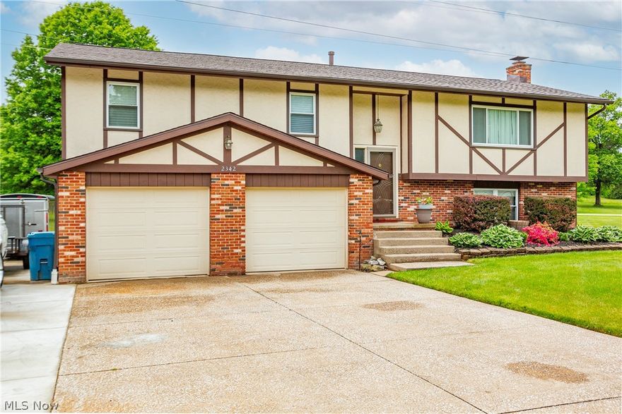 Welcome to 2342 Oak Point Drive! Here you'll find a lovely home in a calm residential neighborhood. This home has noticeable curb appeal. It is well proportioned on over half an acre with ample yard space for you to enjoy. Enter into the main level of the house and you'll find a well-lit living area that seamlessly opens into the dining space. The eat-in kitchen features stainless steel appliances, newly painted cabinets, and LVP flooring. Unwind in the jet tub of the main level bathroom located close to the 3 bedrooms. The primary bedroom features a walk-in' closet and its own 1/2 bathroom. On the lower level, you'll find further living space that has potential for various uses. The gas-burning fireplace adds an extra charm to the atmosphere. In addition to the oversized 2-car garage, there is plenty of additional parking space in the driveway that also has an added concrete slab. Chill out and relax with loved ones on the backyard patio or enclosed sunroom after a long day. There is a great deal of possibilities here. Make this home yours and take advantage of all it has to offer!