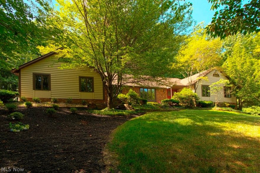 Beautiful. large three bedroom ranch adjoining the Holden Arboretum mountain walk. A nature lover's dream. The ranch sets on two wooded acres, has a walk out finished lower level. The home has been updated with beautiful crown molding in every room. The entry way has wainscoting and crown molding. The formal dining room also has wainscoting and crown molding. The great room has built in bookcase and wet bar, plus a sandstone fireplace and with paneled wall. The dinette, laundry and half bath have bead board trim. Off the master bedroom one can walk out to a cover porch for a restful retreat in the woods. The lower level has a workout/office area that opens up to a large great room with beautiful windows, wet bar, wine refrigerator, a built in buffet table, pool table, and patio outside. On the main level is a large deck and paved walkway to the covered porch. There are two skylights-one in the kitchen and one in the master bath. This home is move in ready.